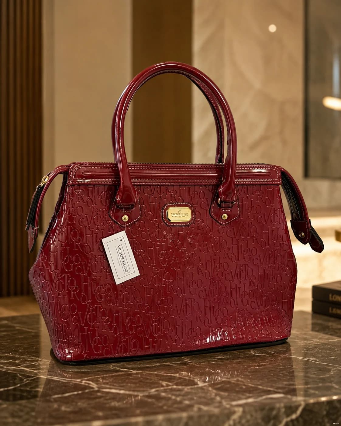 Cartera estructurada en tono bordó, con acabado brillante, textura en relieve y detalles dorados. Amplia, elegante y con una presencia que transforma cualquier look.